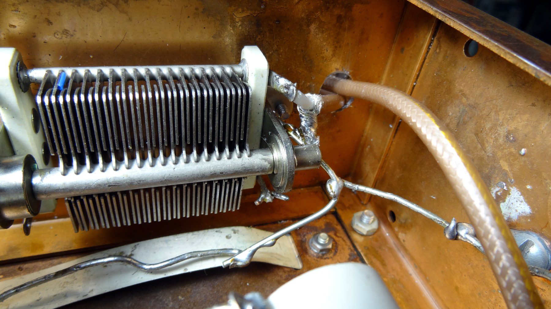 Figure 7 — The final's tank tuning capacitor, wide-spaced transmitting type, with the coaxial output lead. Plate spacing is what allows a pi network to be tuned through resonance at 740 volts without arcing.