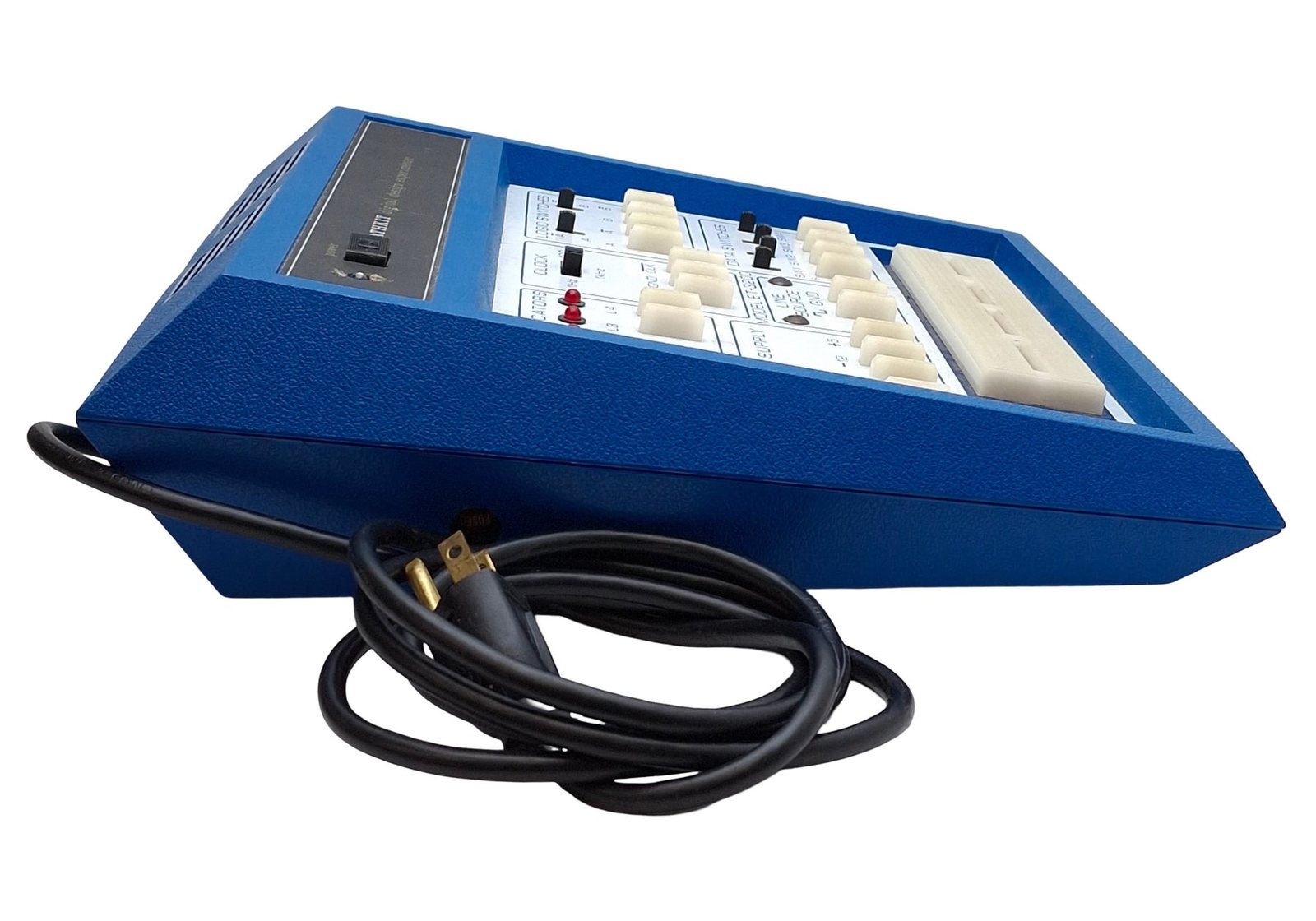 Figure 6 — An ET-3200A in the original blue cabinet from the right front, showing the sloping panel, the spring-contact terminal blocks standing proud of the board, and the three-pin plug on its cord.