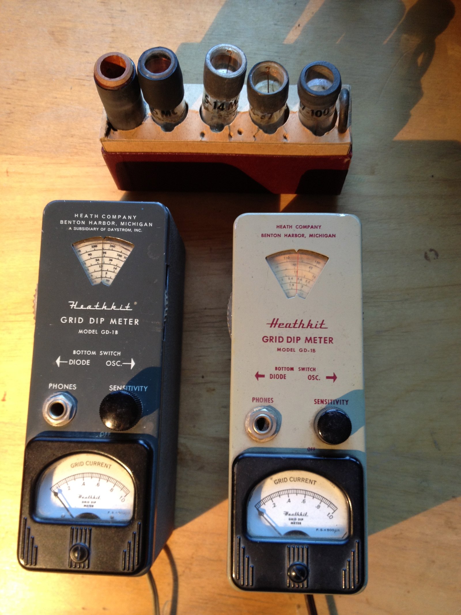 Figure 4 — Two GD-1B grid-dip meters with a rack of plug-in coils. The grid dipper was Heath's first product for radio amateurs. It was sold as a test instrument, and its success was what persuaded the compan…