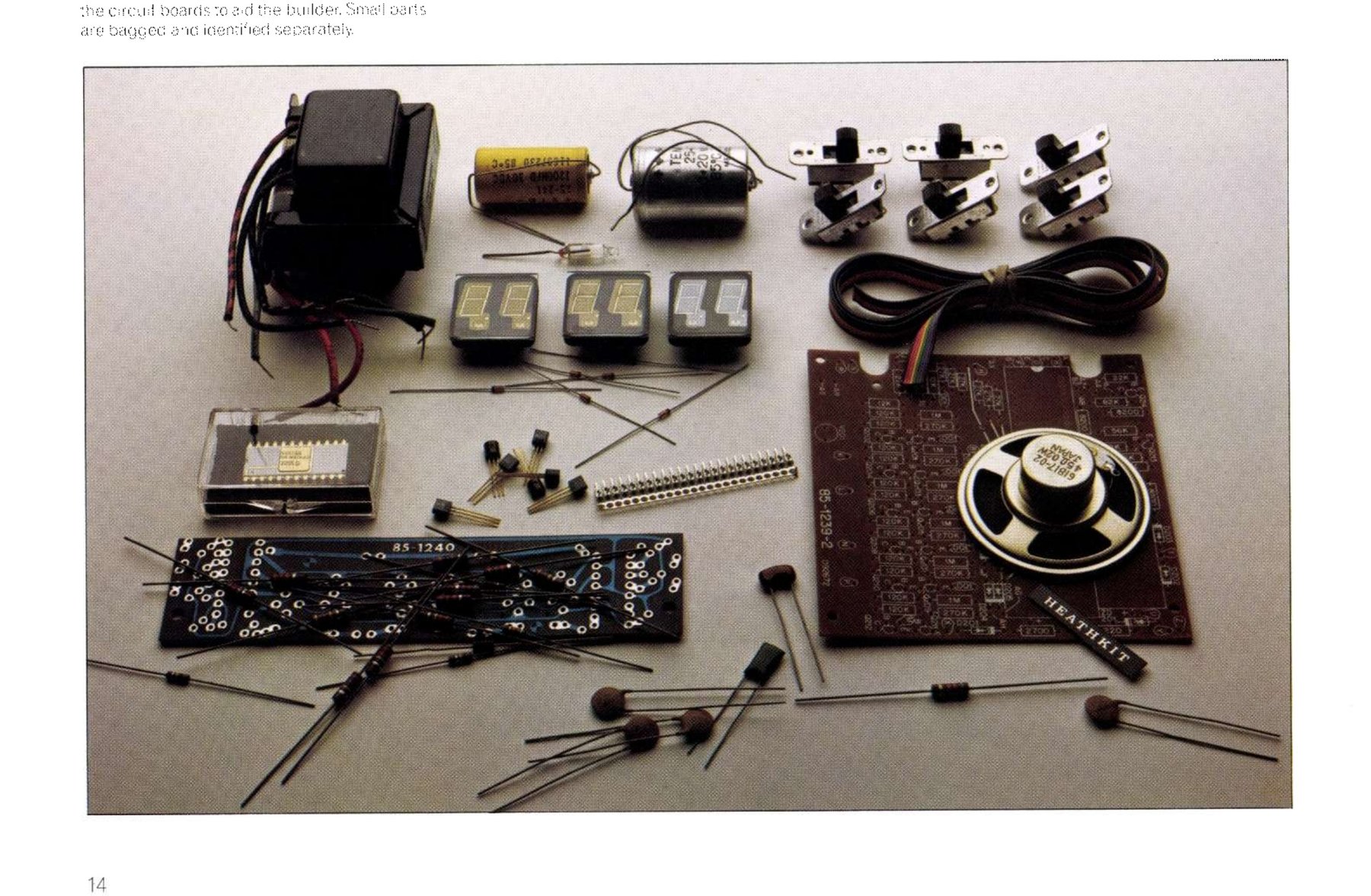 Figure 20 — The parts of the Heathkit electronic clock laid out before assembly: two printed boards with component values and positions printed on them, bagged and identified small parts, and the digital displ…