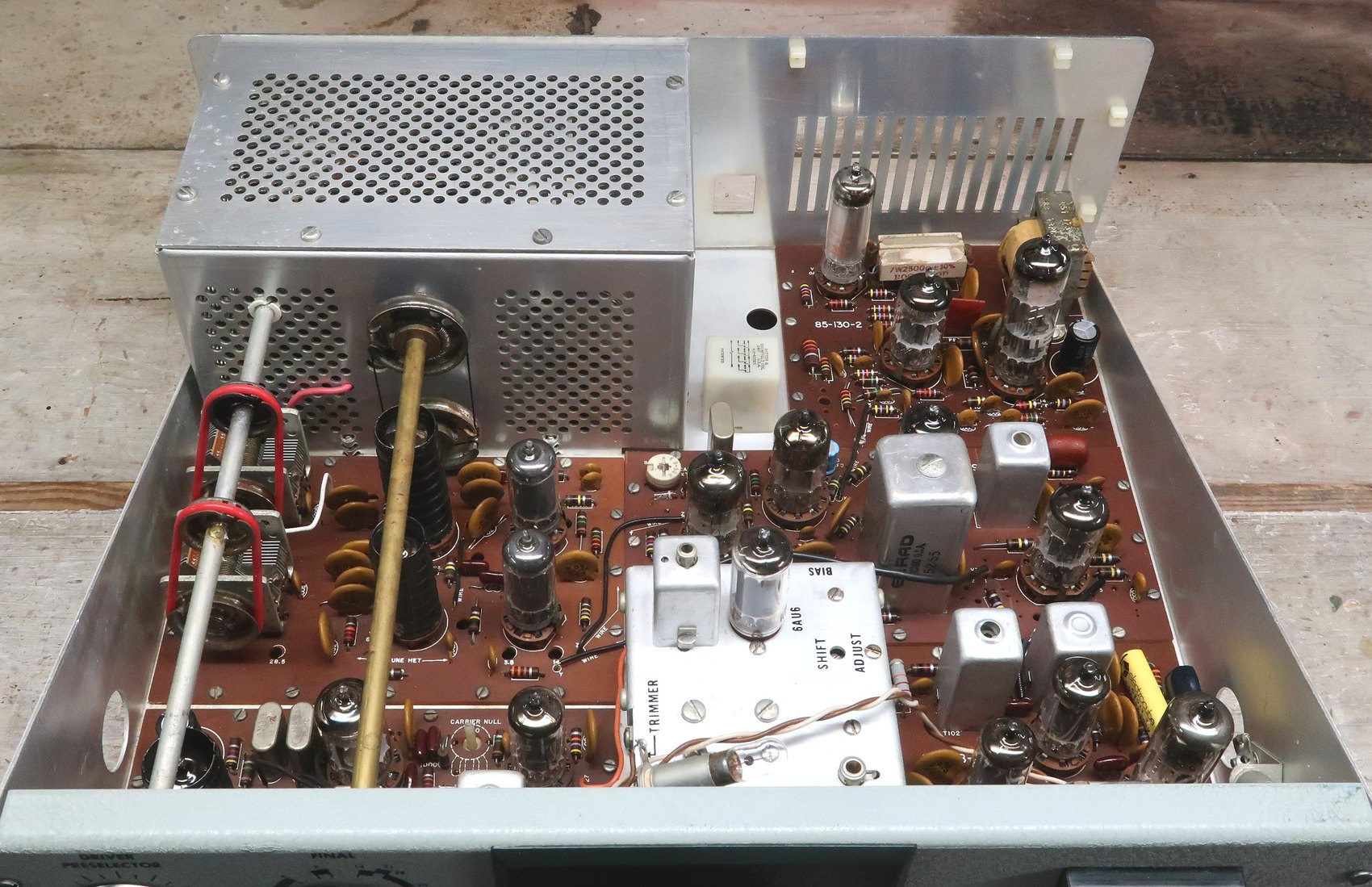 Figure 11 — Top of the chassis with the cover off. The five circuit boards sit above the chassis with the shielded VFO box at the left and the enclosed final amplifier cage at the right; the two large air-vari…