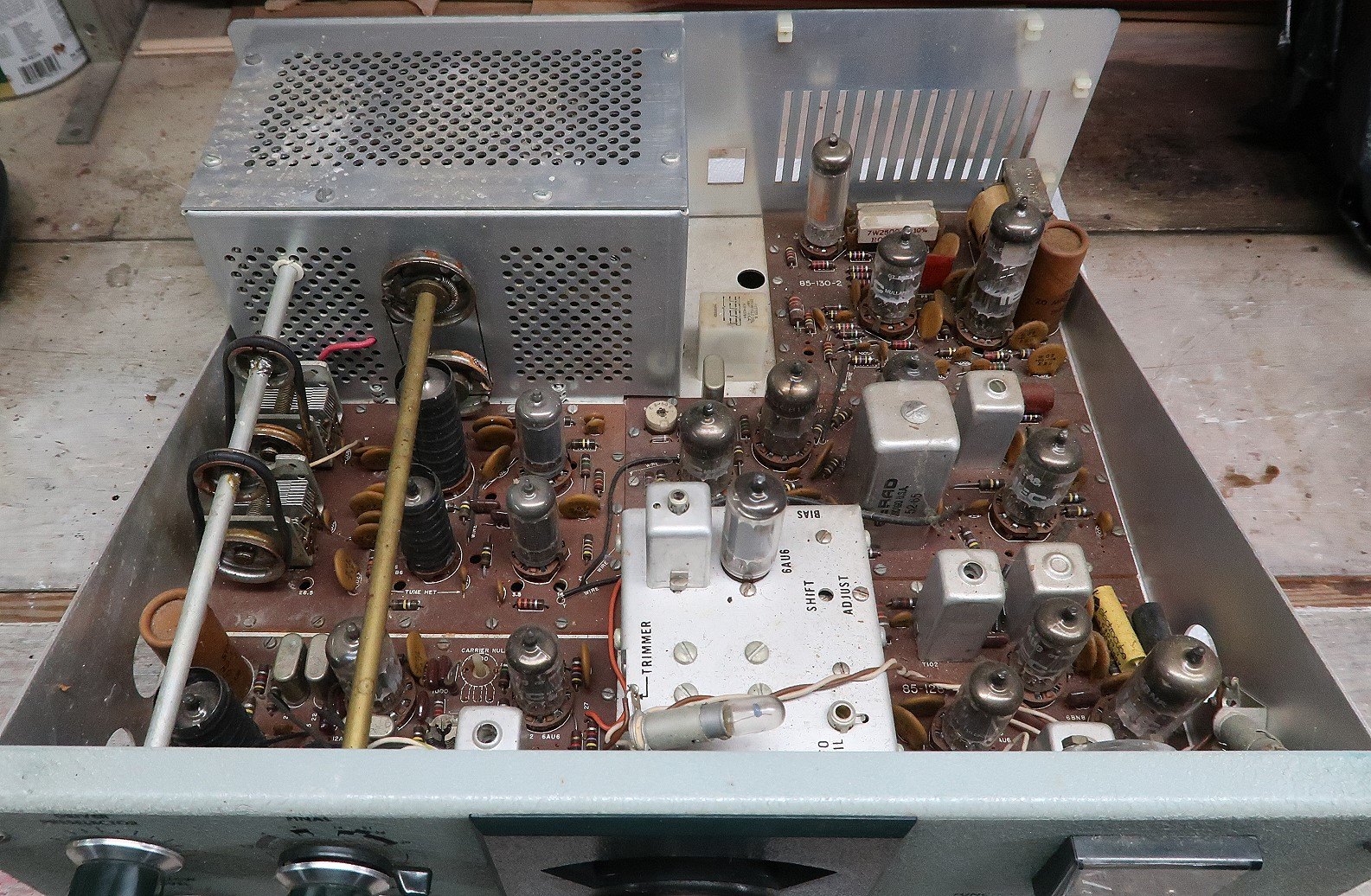 Figure 2 — Inside an unrestored set. The yellow haze on the boards and the dust between the coil cans are ordinary; what matters is what is underneath them.