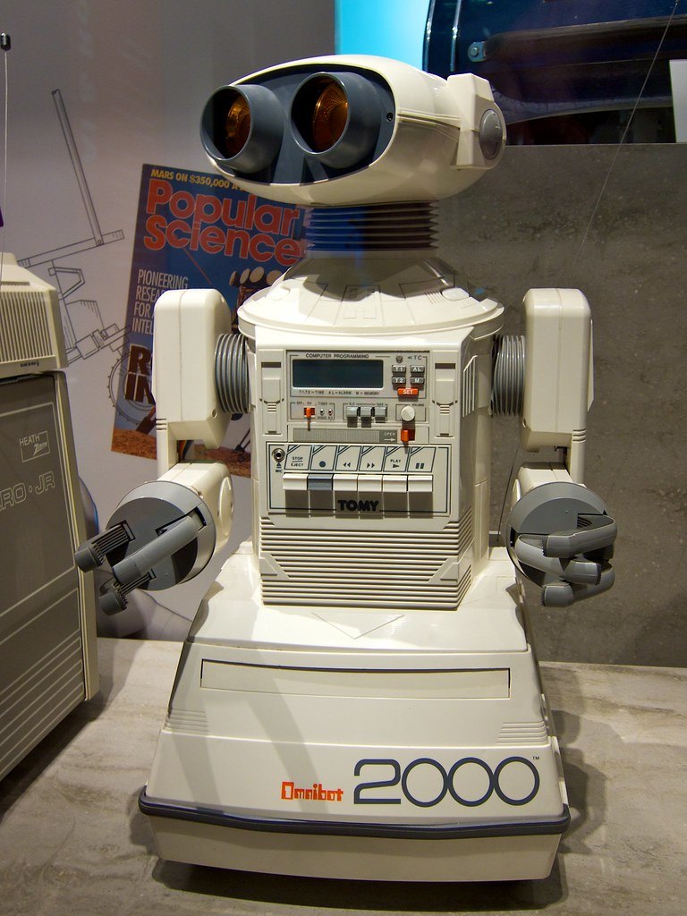 Figure 12 — Tomy's Omnibot 2000, the toy end of the same wave. Robotics Age's editor, reviewing its predecessor the Omni-bot at the June 1984 Consumer Electronics Show, called it "definitely a toy" at a retail…