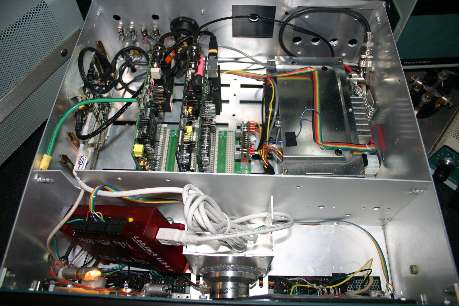 Figure 5 — An SB-104 chassis rebuilt around HPSDR software-defined-radio boards: the original VFO knob and panel remain, the plug-in boards are gone, and modern modules sit in the partitioned chassis.