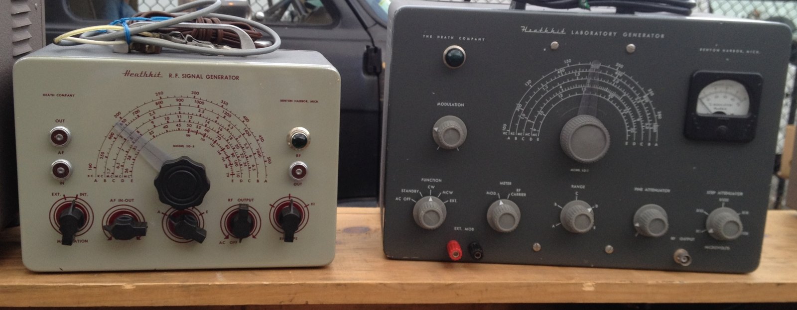 Figure 7 — The two generator lines of the 1950s side by side: an SG-8 R.F. signal generator ($19.50) in grey "Classic I" styling and the larger LG-1 Laboratory Generator ($39.50), with its output meter, funct…
